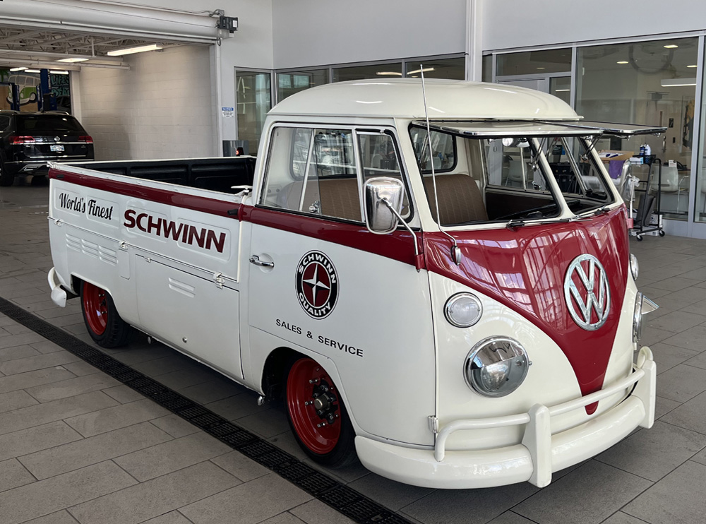 1967 VW Single Cab The Dude restored as a Schwinn shop truck, featuring red and cream paint, displayed indoors at a Volkswagen showroom