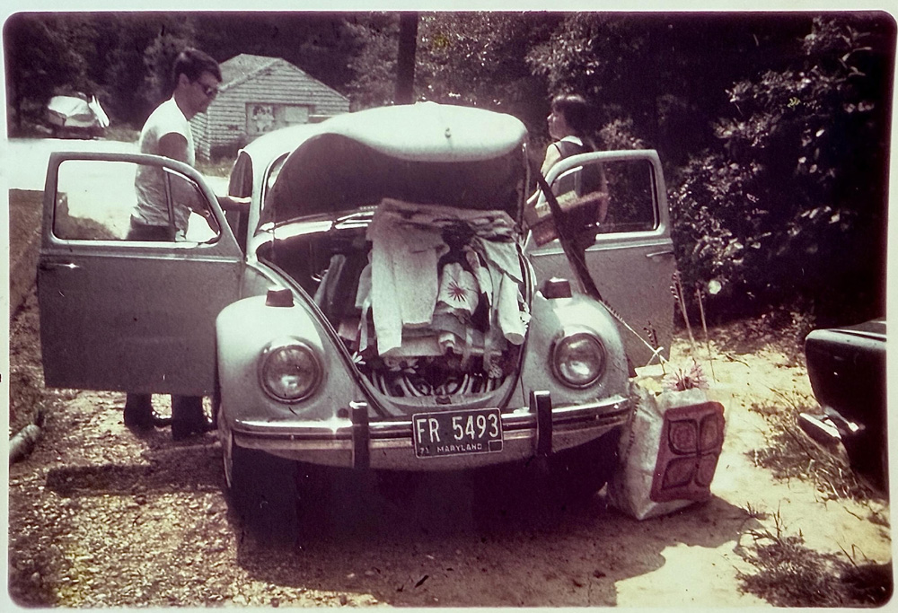Vintage Volkswagen Beetle packed for a trip, Dave Cooks parents standing beside it in a rural setting