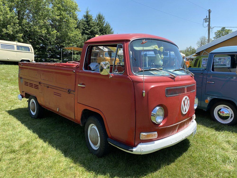 Red Volkswagen Type 2 pickup truck displayed at Bug Out 44 on grassy field