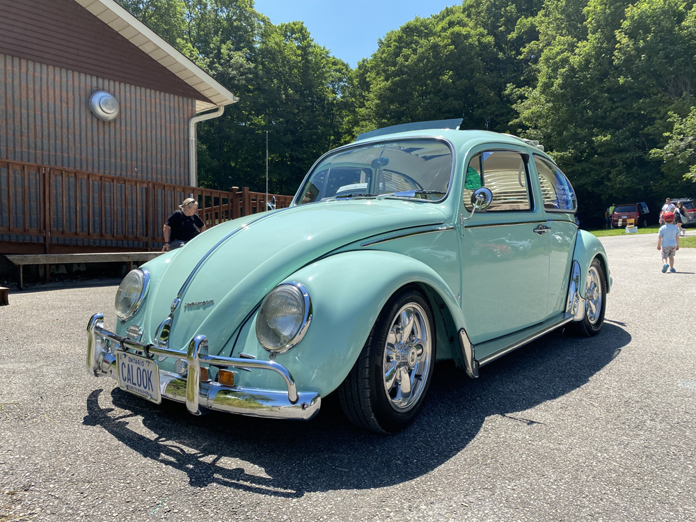 Light green Volkswagen Beetle parked at Bug Out 44 with chrome bumpers and Ontario plate